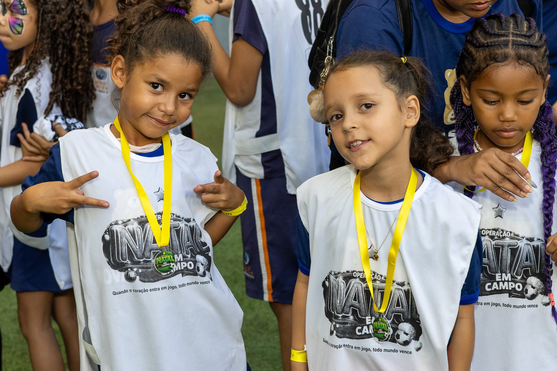 Crianças exibindo medalhas do projeto